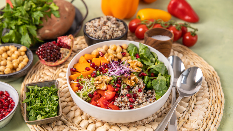 Colorful vegan salad surrounded by fruit