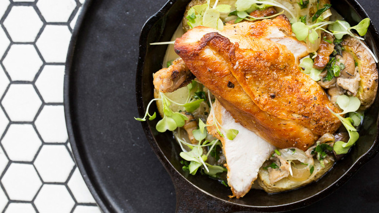 black skillet with chicken over greens