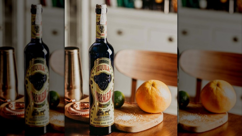 Bottle of Tequila Corralejo Reposado on a table with margarita ingredients