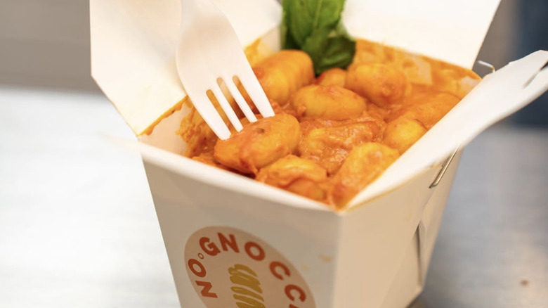 close up of a white carton containing gnocchi in a red sauce