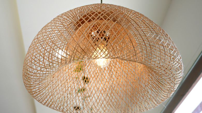 Rattan pendant lamp hanging from white ceiling