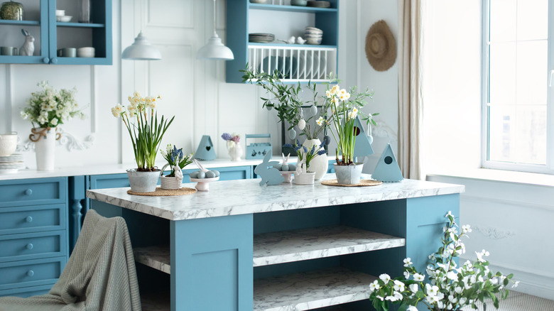 Blue kitchen interior with fresh flowers on the island