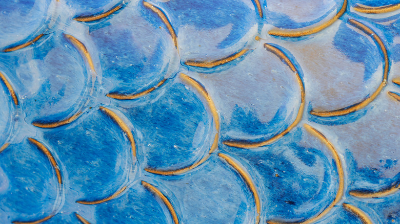Aqua blue ceramic tile pattern replicating mermaid scales