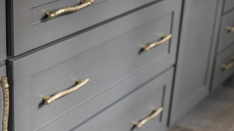 Gray kitchen cabinets with modern gold drawer pulls
