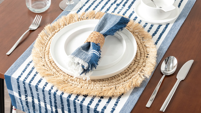 Summery table setting with raffia placemats and striped linen table runner