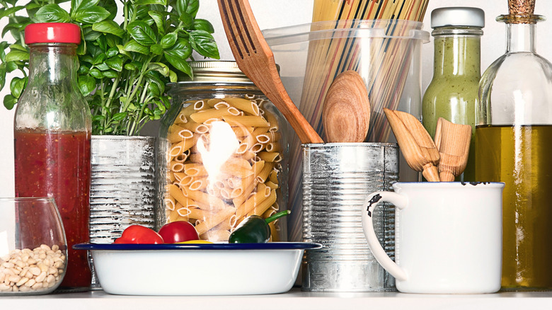 Oil bottle placed at the back of the kitchen cabinet on a crowded shelf