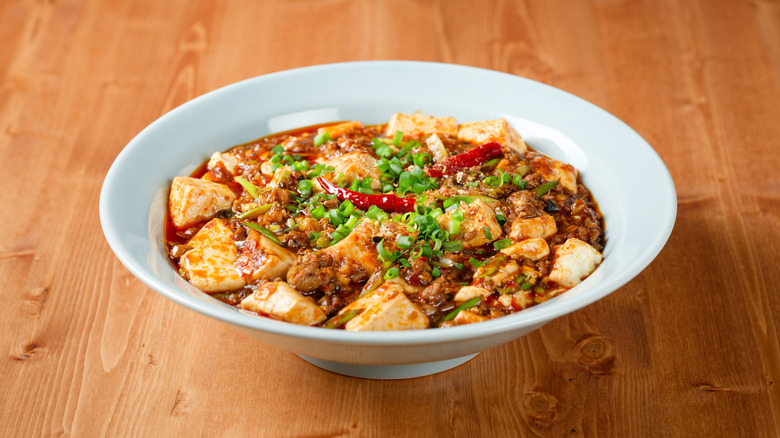A white bowl of Mapo tofu on a table