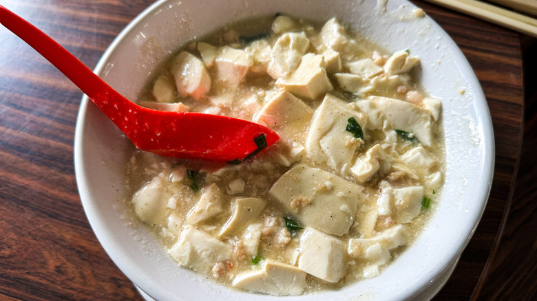 A bowl of Mun Tahu with a red spoon