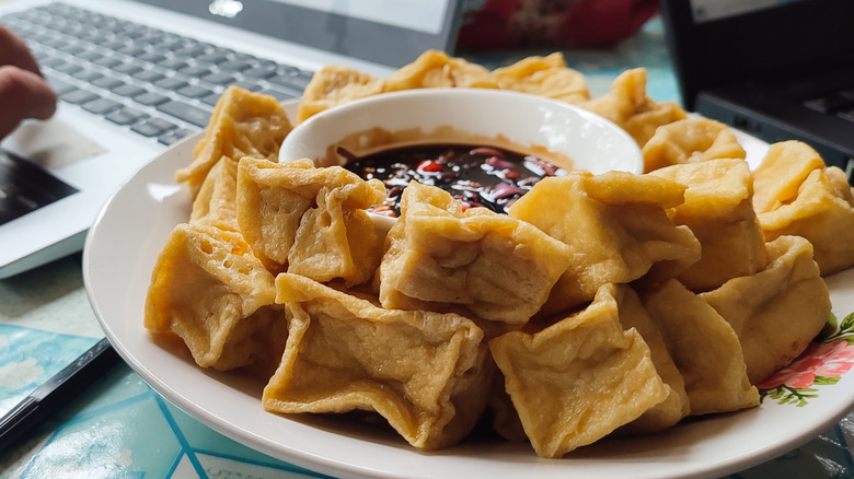Fried tofu with soy sauce and chili sauce on a plate