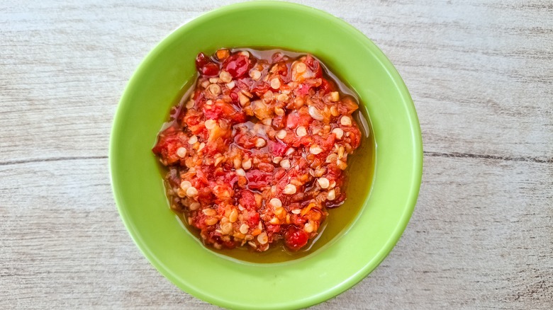 Sambal tomat in a green bowl on a wooden table