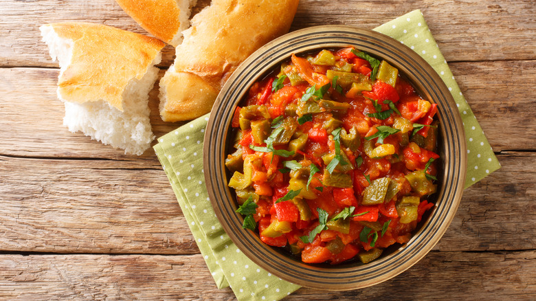 Taktouka in a plate on green spotty tea towel with bread