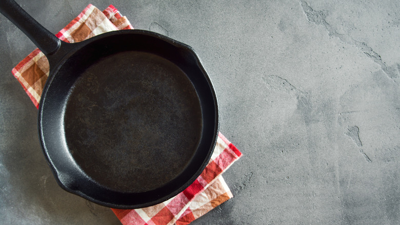 cast iron pan on a red-and-white checkered dish towel
