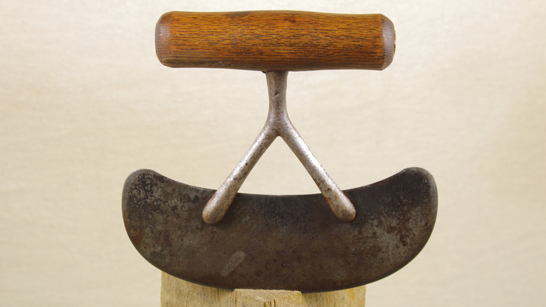 vintage hash knife with a wooden handle on a wood block