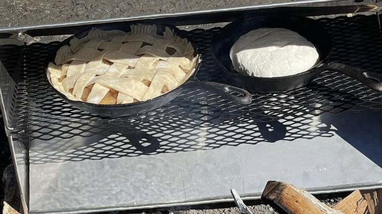 A lattice-topped pie and bread baking in a reflector oven