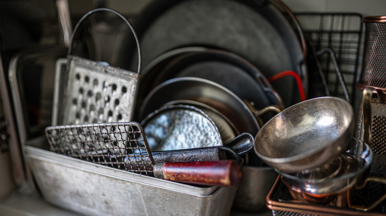 A tinned grater with vintage tools in a metal bin