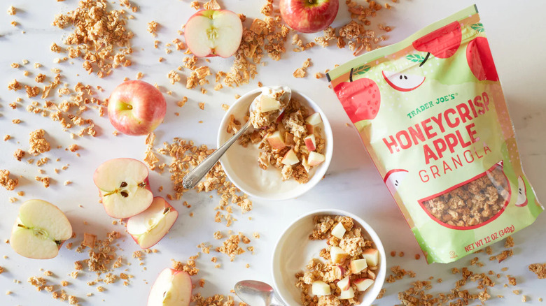 Trader Joe's Honey Crisp Apple Granola spread across table and served in bowls with apples