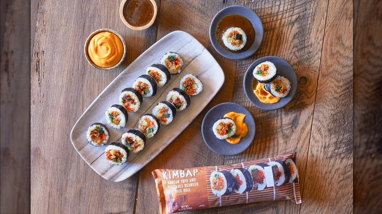 Trader Joe's Kimbap package below kimbap and sauces on serving platter and blue plates