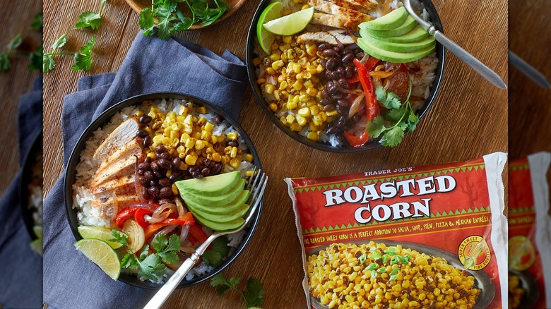 Bag of Trader Joe's roasted corn under two burrito bowls on wooden table