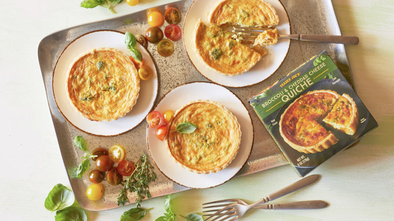 Three Trader Joe's Broccoli & Cheddar cheese quiche plated on a tray, the box in the corner