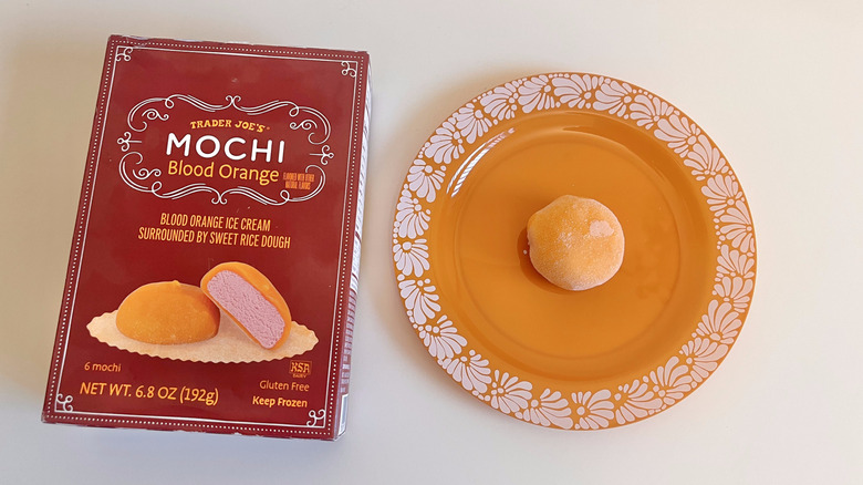 Top view of Blood Orange Mochi on an orange plate and a whole package next to it