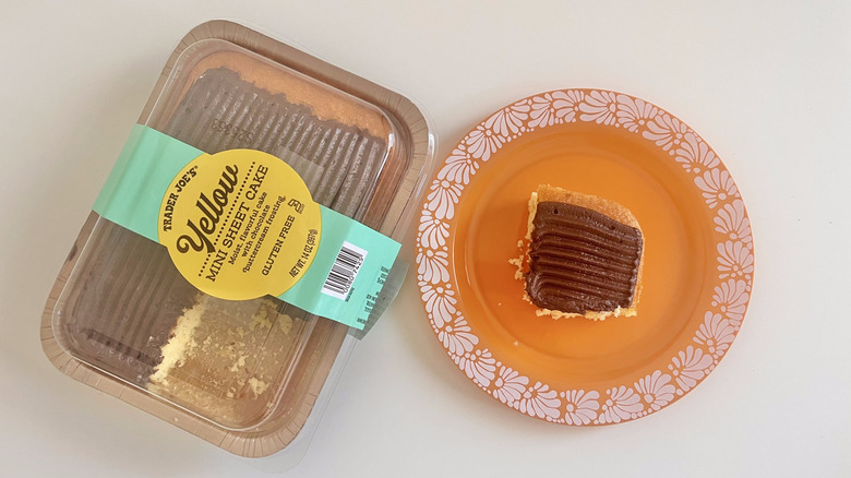 A piece of yellow sheet cake on a plate with a packet of Yellow Mini Sheet Cake from Trader Joe's