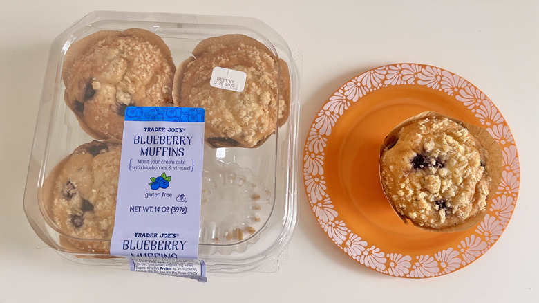 Trader Joe's pack of gluten-free blueberry muffins with one blueberry muffin on a plate