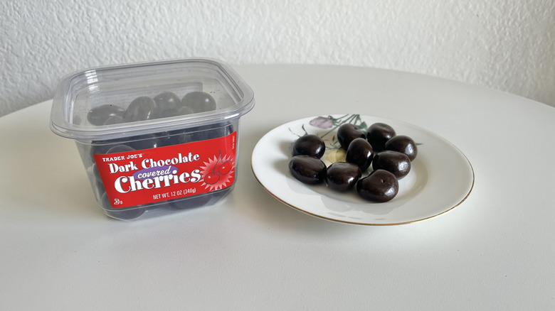 Trader Joe's chocolate cherries container next to a plate of chocolate cherries