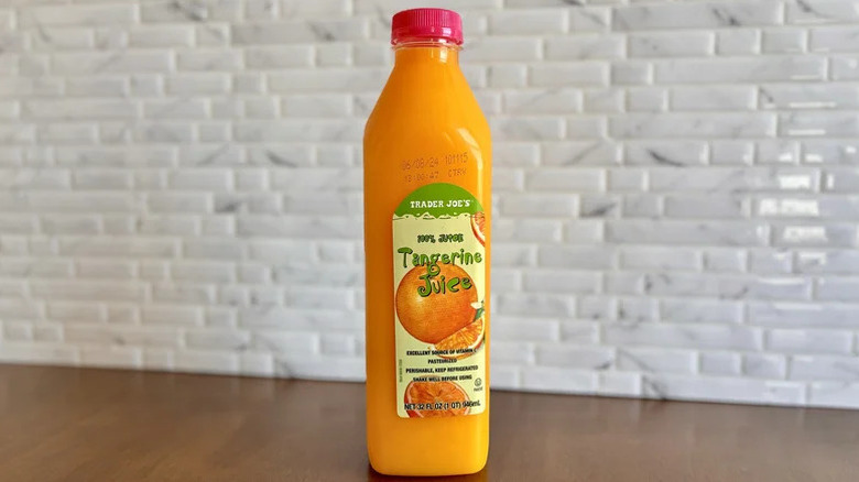 Container of tangerine juice on counter
