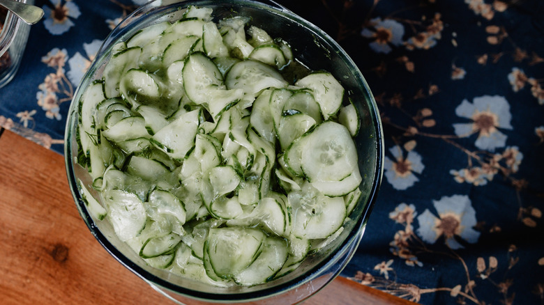 Cucumber salad in a glass bowl on a floral table