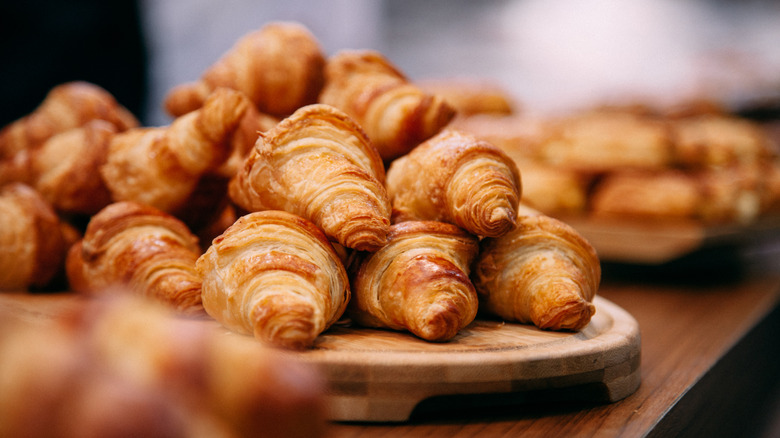 Pile of croissants on wooden serving board