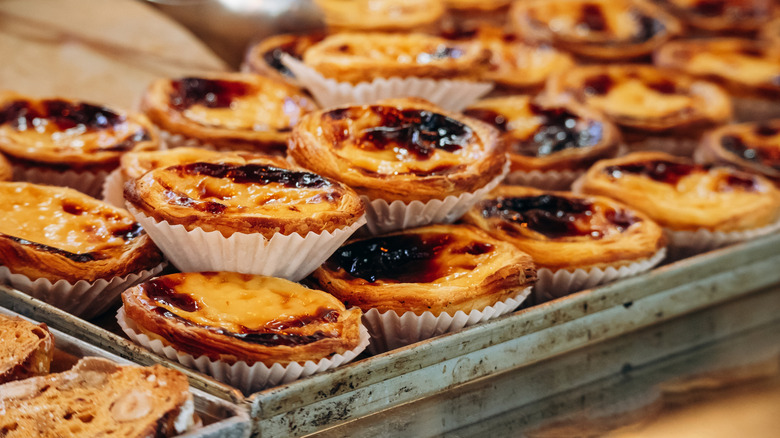 Portuguese pastel de nata pastries displayed in rustic tray