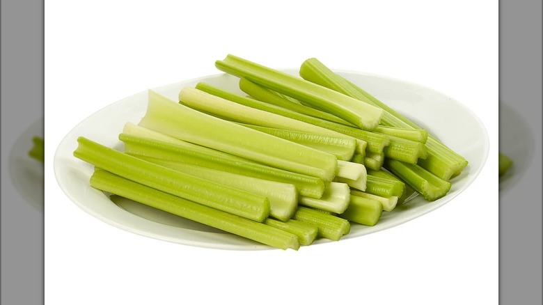 A pile of trimmed celery sticks on a plate