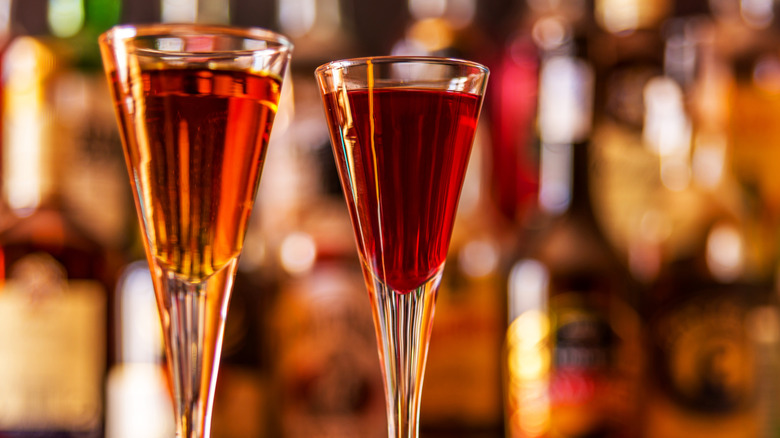Two tall glasses of liqueur on blurred background