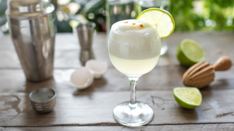 Pisco sour cocktail with limes, eggshells, and shaker
