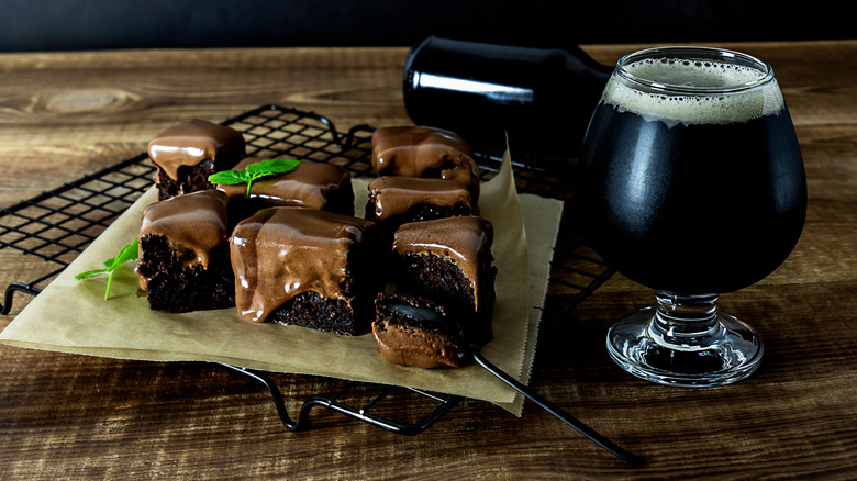 A glass of beer and a plate of chocolate brownies.