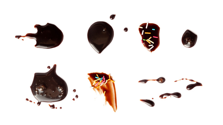 A smeared variety of chocolate sauces and soy sauces with sprinkles.