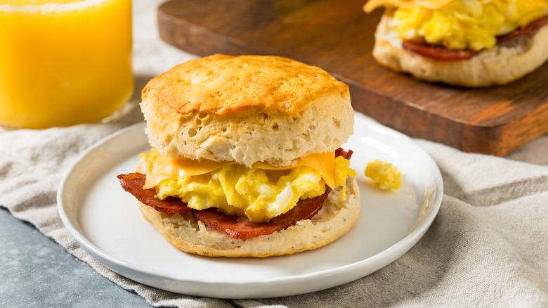 breakfast egg and bacon biscuit sandwich on a white plate
