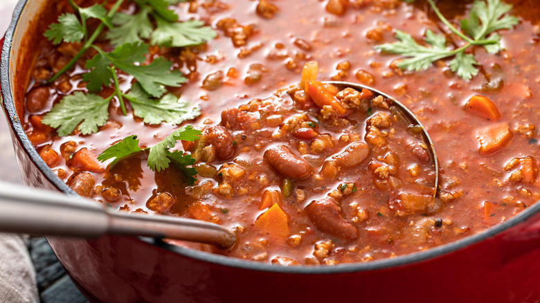 A pot of chili with beans, ground beef and cilantro