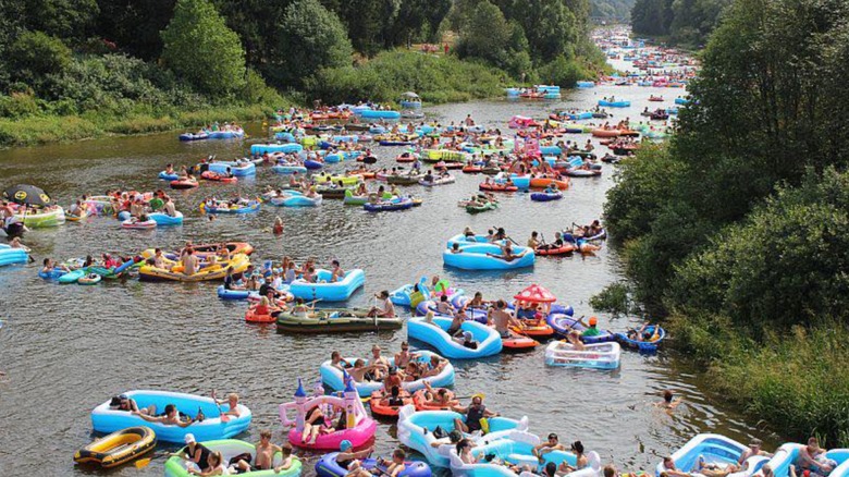 Hundreds of people on inflatable boats and tubes on a large river
