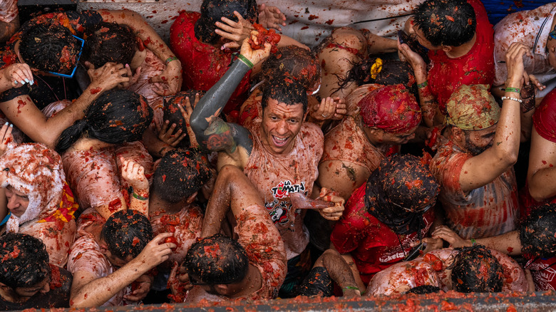 An aerial shot of people covered in tomatoes during La Tomatina in Spain