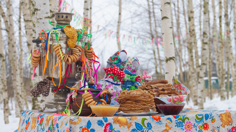 A festive, colorful table with blini and trinkets during the Maslenitsa Festival