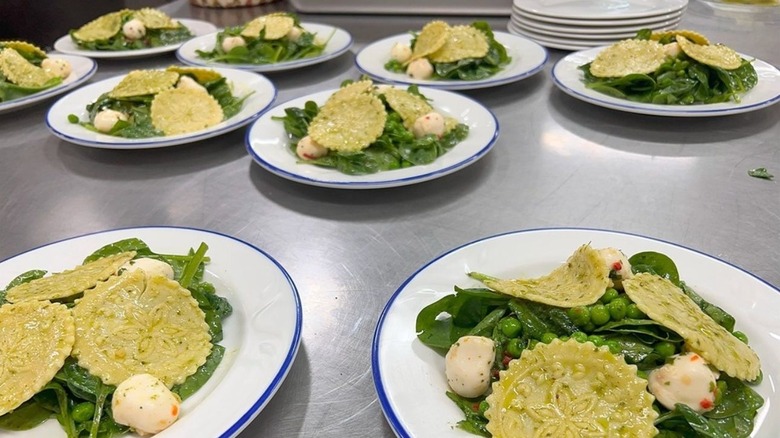 Pretty designs on corzetti served on plates with greens and buffalo mozzarella