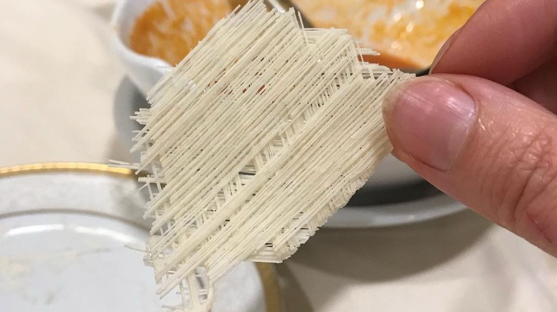 Fingers holding finely spun filindeu