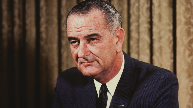 color photo of Lyndon B. Johnson with brown curtains in background