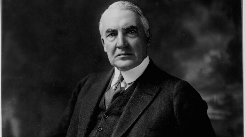 black and white portrait of Warren Harding in suit against cloudy background