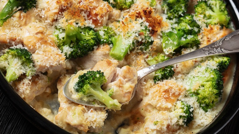 Spooning chicken divan casserole out of baking dish