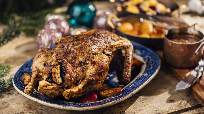 Roasted duck on a blue plate as part of a Christmas spread