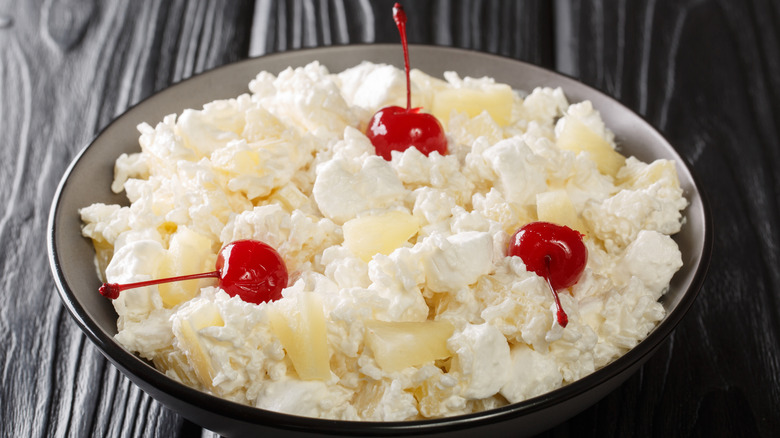 Pineapple fluff with maraschino cherries in a grey bowl