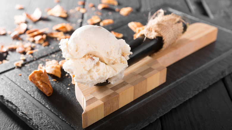 Scoop of walnut ice cream on cutting board