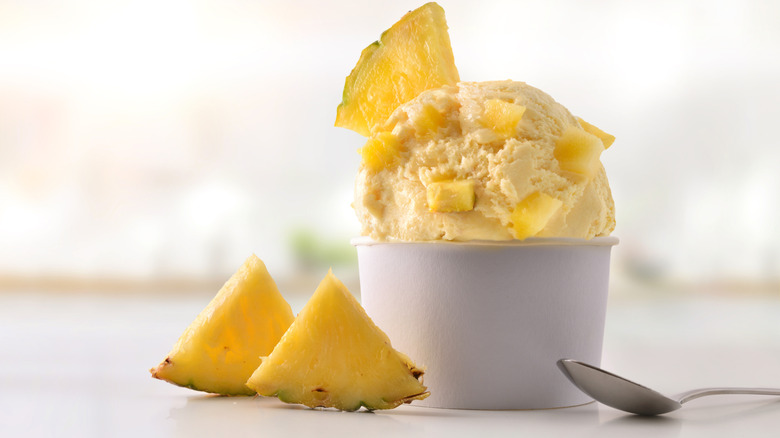 Bowl of pineapple ice cream with slices and chunks of pineapple